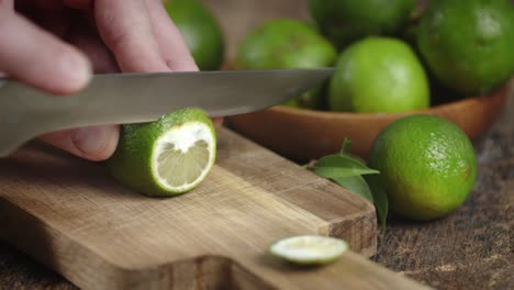 male hand with a knife cut fresh lime.