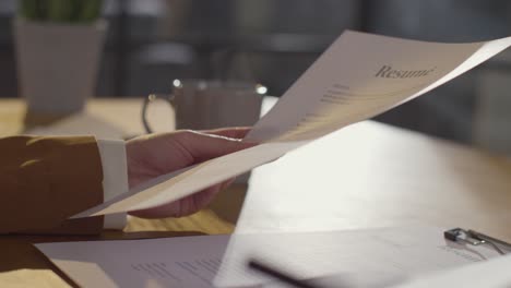 close up of businesswoman in office reviewing and making notes on application or cv for job vacancy 2