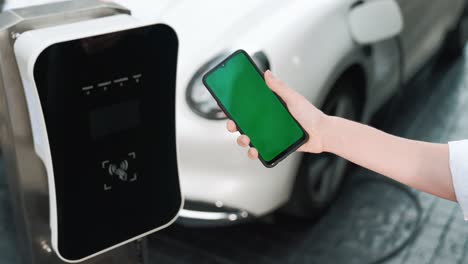 concepto progresivo de pantalla verde modelo de teléfono, coche eléctrico y estación de carga.
