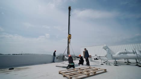 the construction tower crane is lifting a load onto the roof.