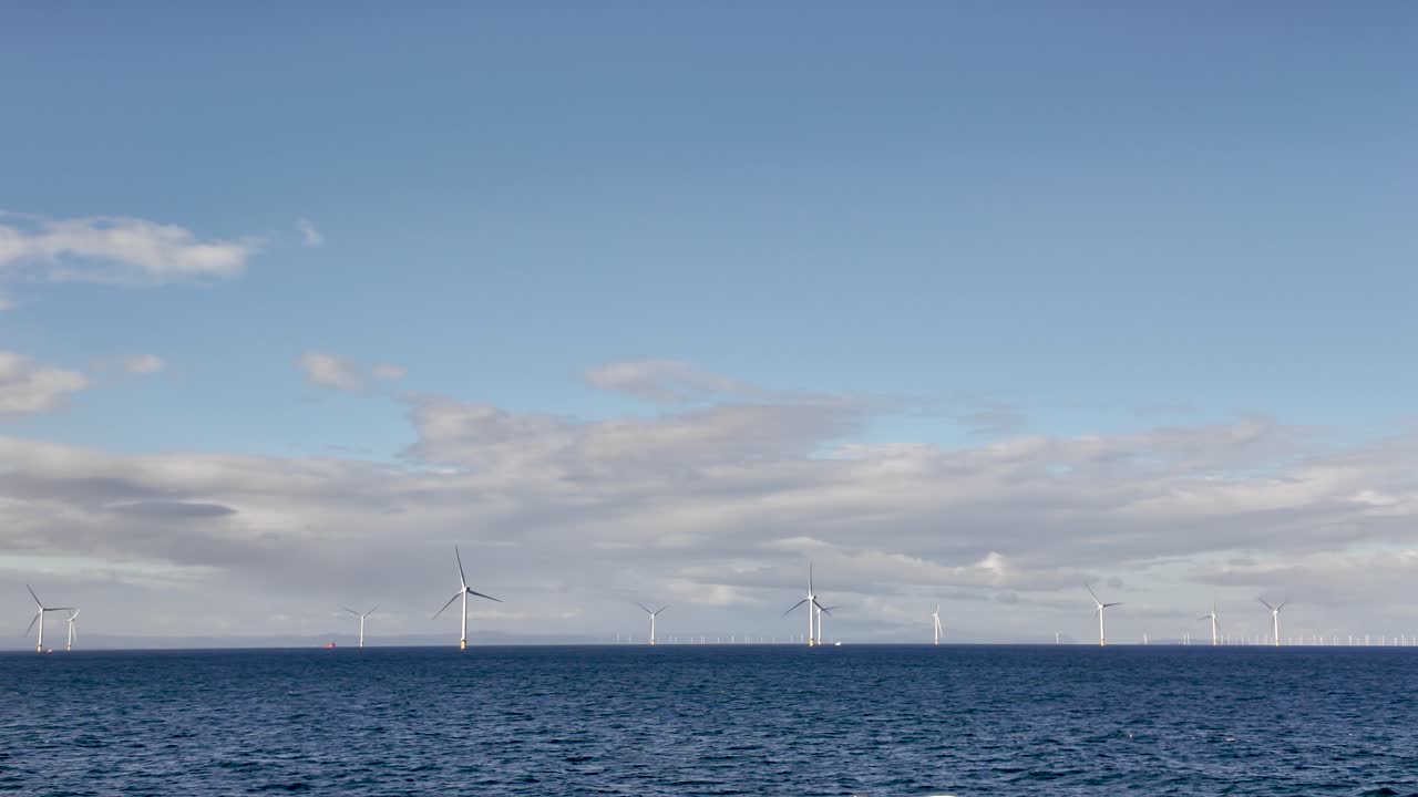 Offshore wind farm turbines are rotating in the Irish Sea, generating sustainable renewable energy