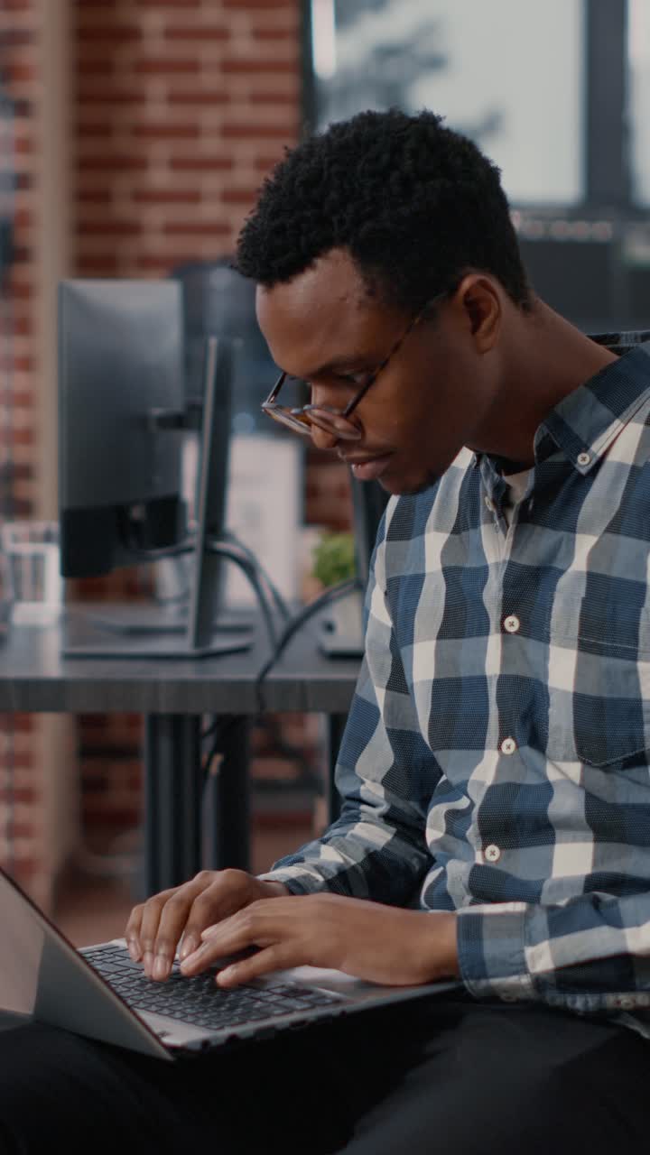 Mann som jobber på bærbar datamaskin på kontoret