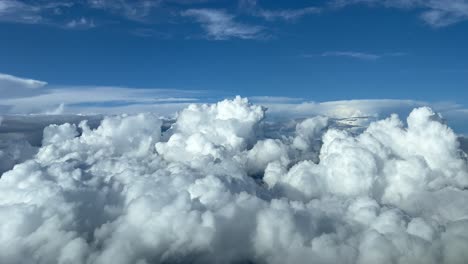 impresionante vista desde una cabina de jet sobrevolando un tormentoso cumulonimbus nubes con un cielo azul profundo