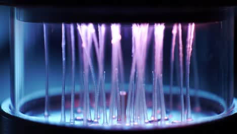 a close-up exploration of an innovative light source system illuminating precision filaments in a transparent enclosure, showcasing intricate design and functionality