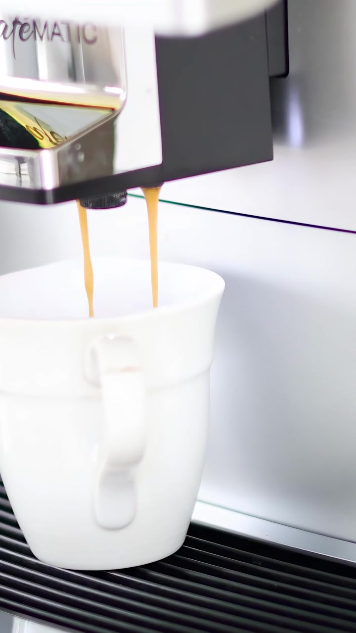 Automatic espresso machine dispensing coffee into cup