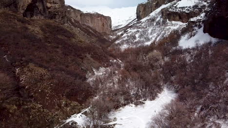 Flying-over-rugged-terrain-in-the-winter-landscape