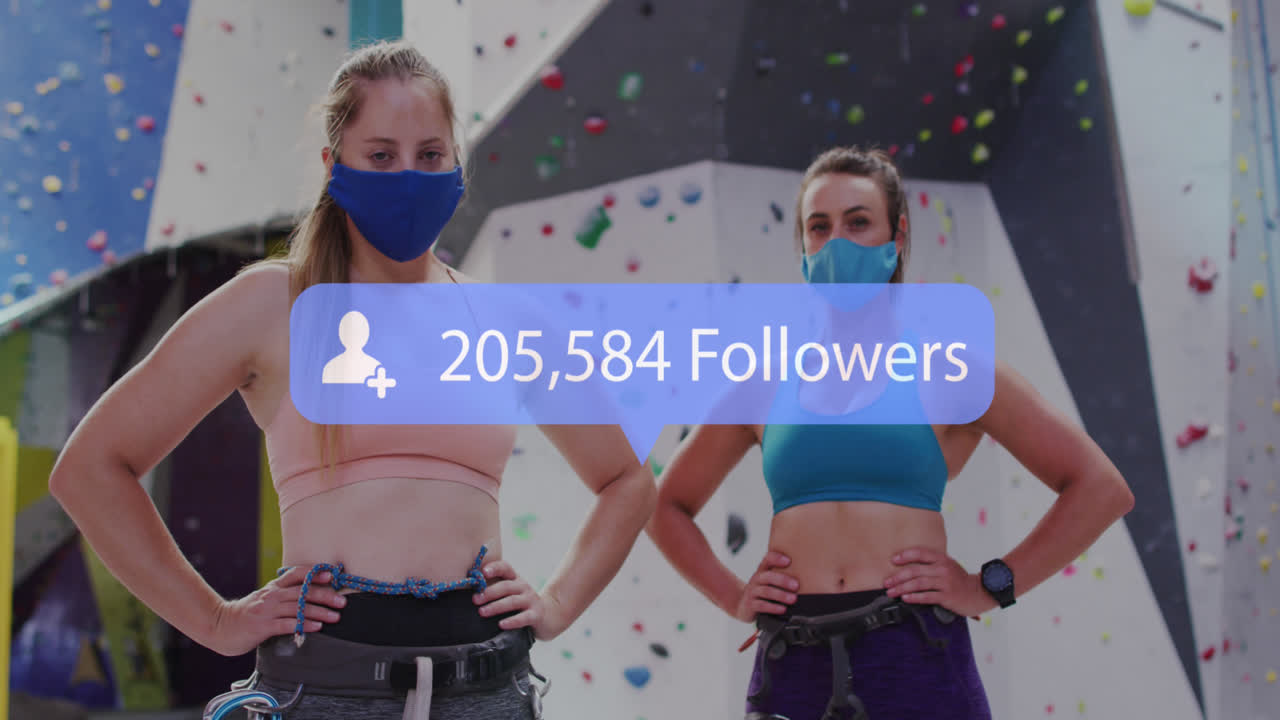 анимация медиа-иконы над двумя кавказскими женщинами с масками на стене для скалолазания