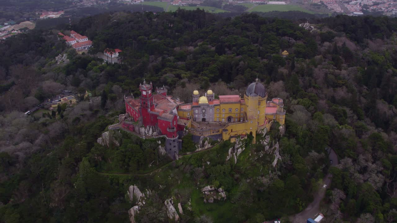 Wide shot of the incredible Pal&aacute;cio da Pena in Sintra during cloudy day, aerial