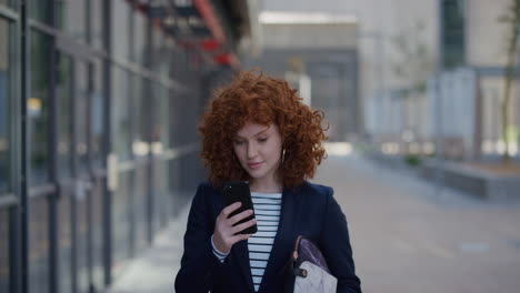 retrato de una joven mujer de negocios con estilo que usa un teléfono inteligente en la ciudad disfrutando de mensajes de texto navegando mensajes en el teléfono móvil sonriendo feliz a cámara lenta satisfacción del estilo de vida