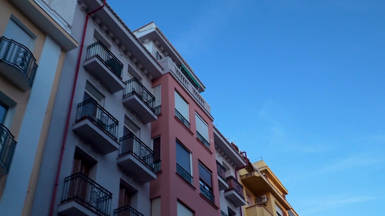 Una ripresa dal basso che guarda verso vivaci condomini con balconi contro un cielo azzurro limpido a Madrid. Adatto per contenuti di viaggio, immobiliare e stile di vita urbano