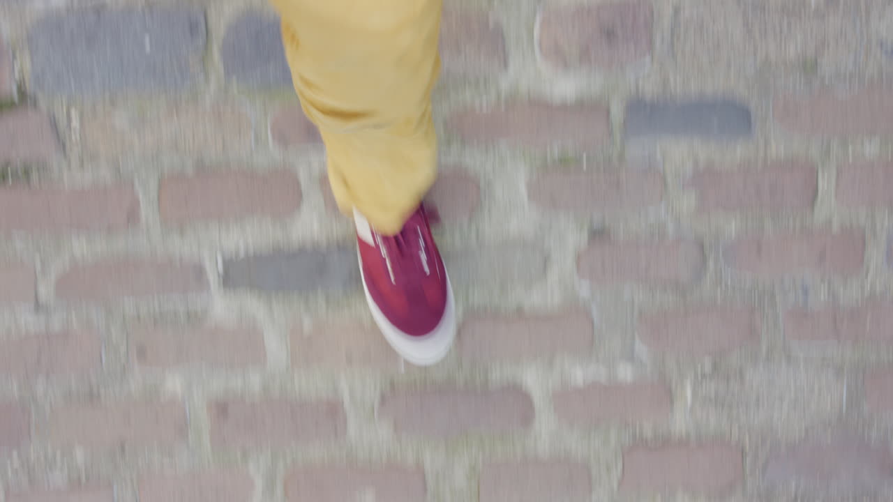 hombre caminando por la acera con zapatos coloridos paseando casual en la vista superior de la ciudad