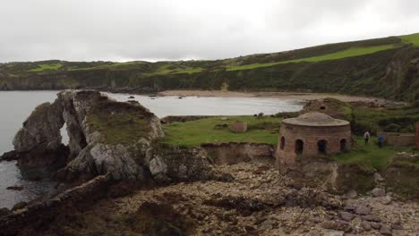 Porth-Wen-aerial-pull-back-view-abandoned-Victorian-industrial-brickwork-factory-remains-on-Anglesey-eroded-coastline