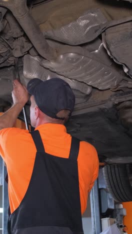 mechanic working on a car's underbody