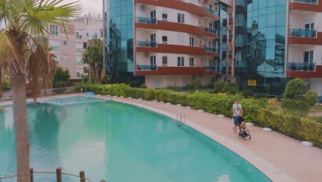 father with child by pool at resort