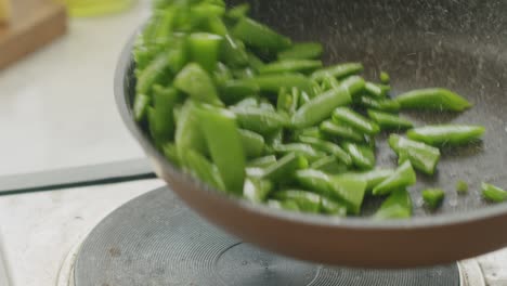 unrecognizable cook frying green beans in pan