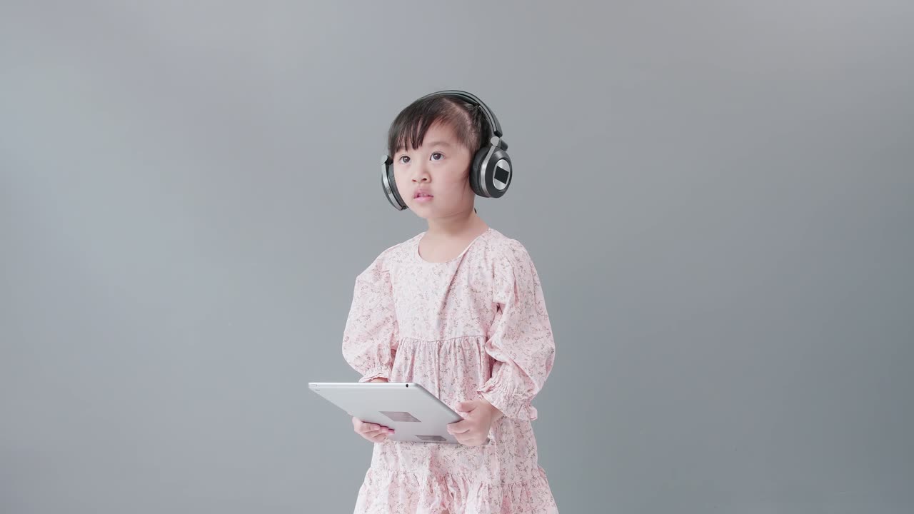 헤드셋을 끼고 디지털 태블릿으로 비디오를 보는 어린이