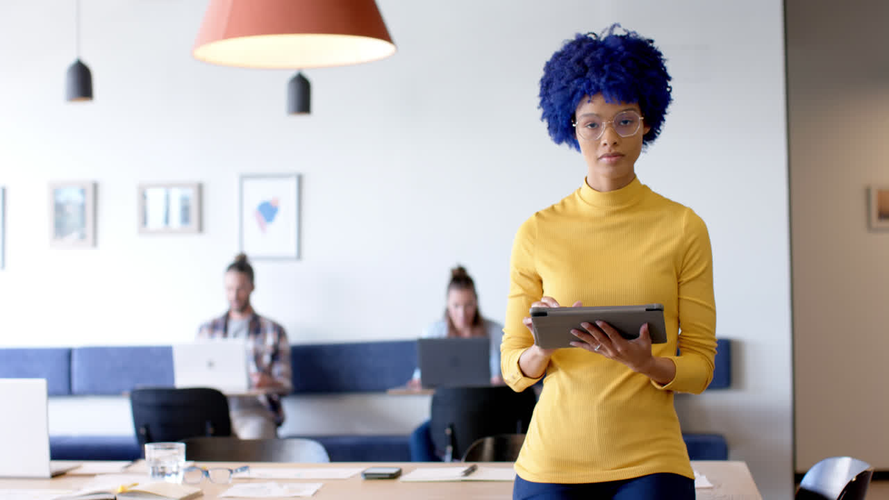 Portrait of creative casual businesswoman with tablet in office with diverse colleagues, slow motion