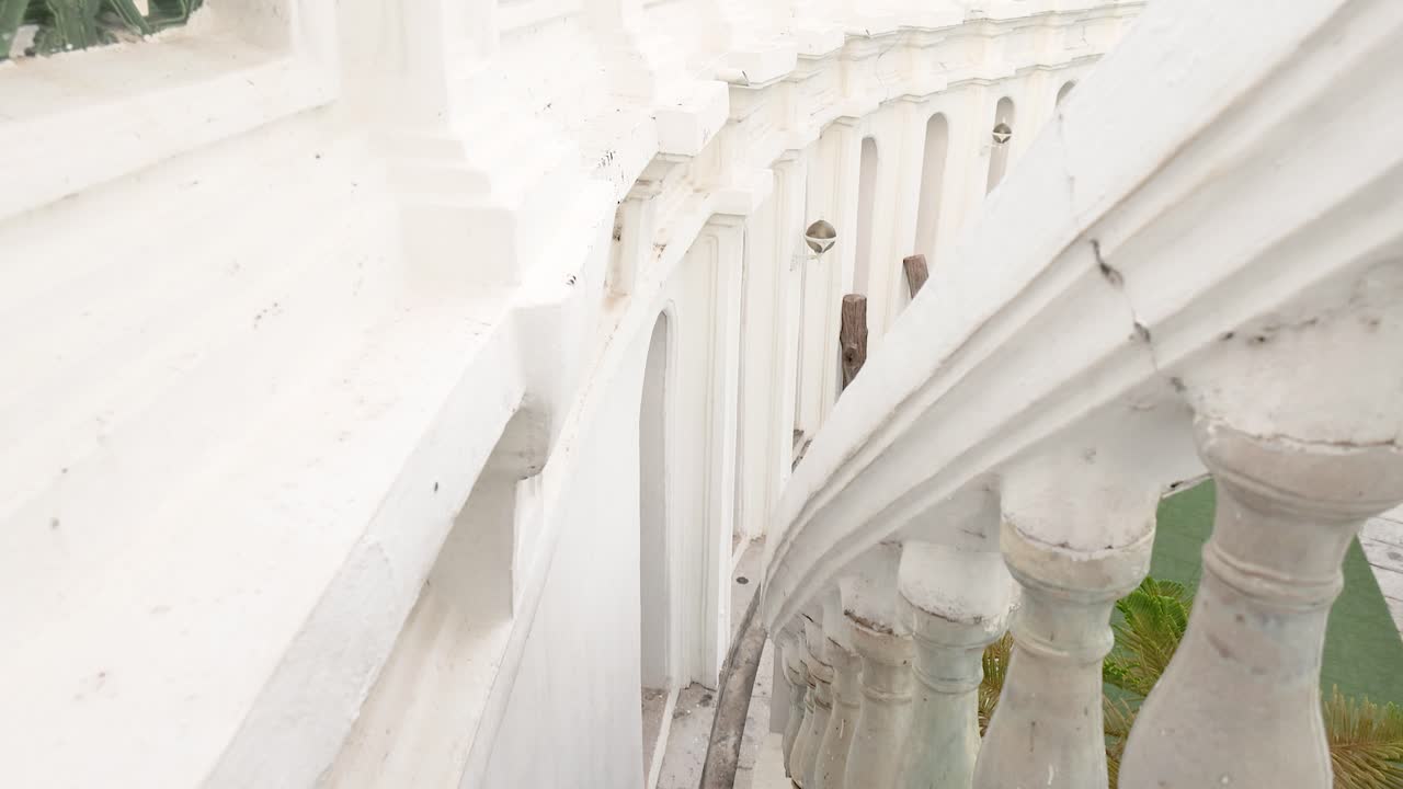 спокойная прогулка по сложной белой архитектуре wat prayurawongsawat в бангкоке, демонстрируя его элегантные кривые и спокойную атмосферу