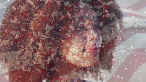 animation of flag of united states of america and confetti over african american woman on beach