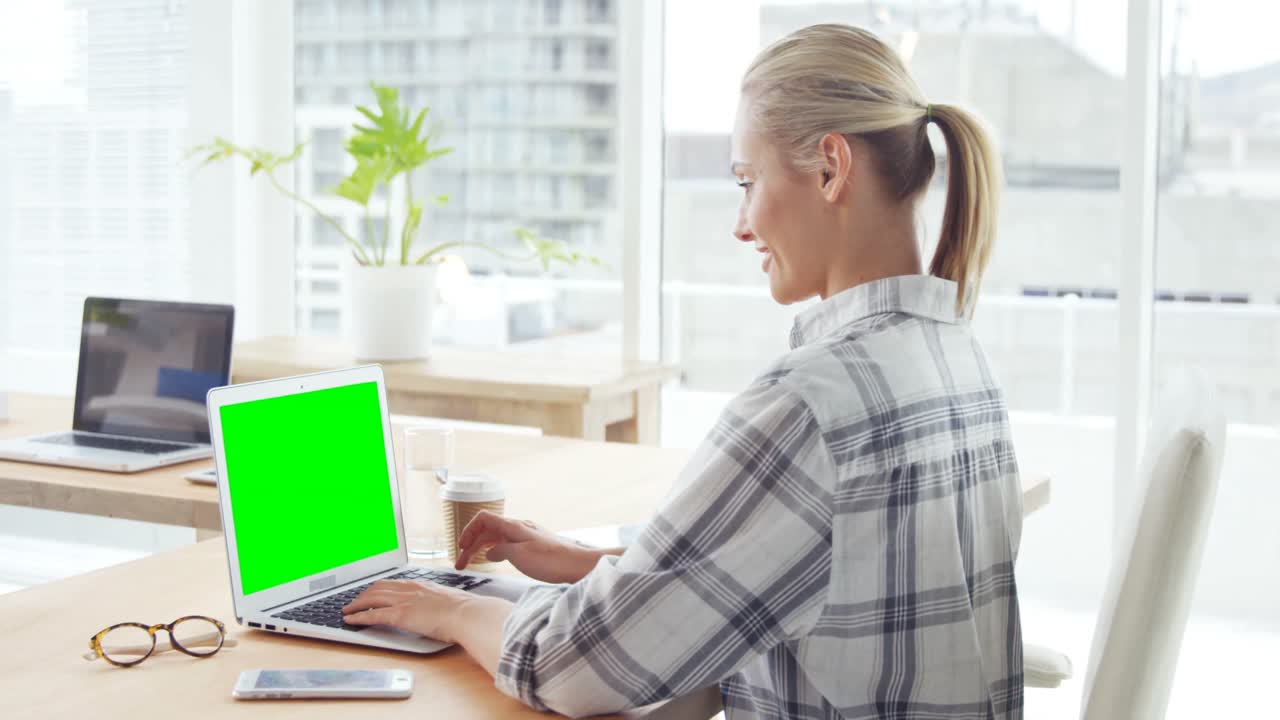 mujer de negocios trabajando en una computadora portátil en su escritorio