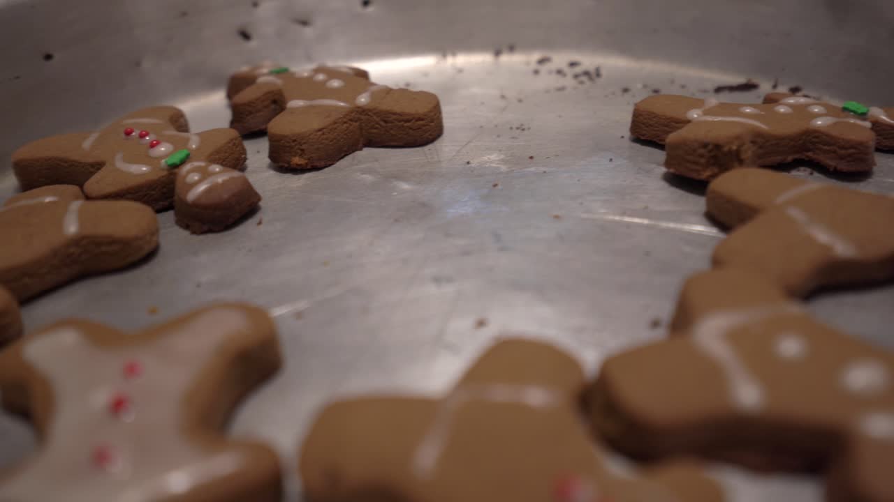 Close-up sliding shot of gingerbread man cookies laying in a baking tray