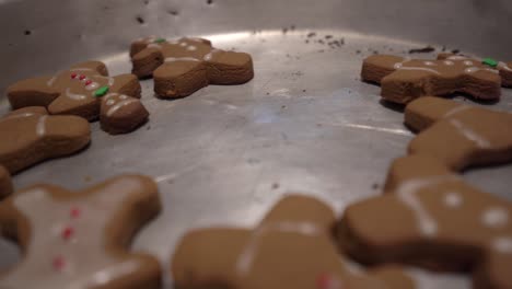 close-up sliding shot of gingerbread man cookies laying in a baking tray