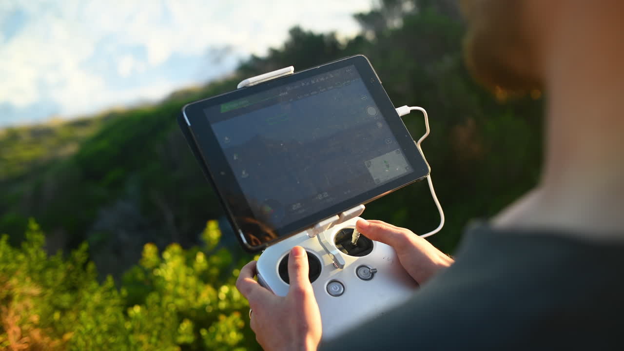 그의 드론이 가면서 전망을 확인하고 있습니다.