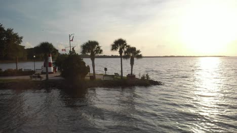 Aerial-drone-wide-shot-slow-pushing-in-marina-boat-dock-with-lighthouse-at-the-bay