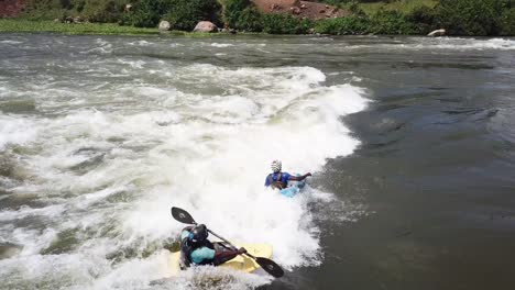 3-Kayakistas-Descendiendo-Por-Las-Rápidas-Aguas-Del-Río-Nilo-En-Jinja,-Uganda