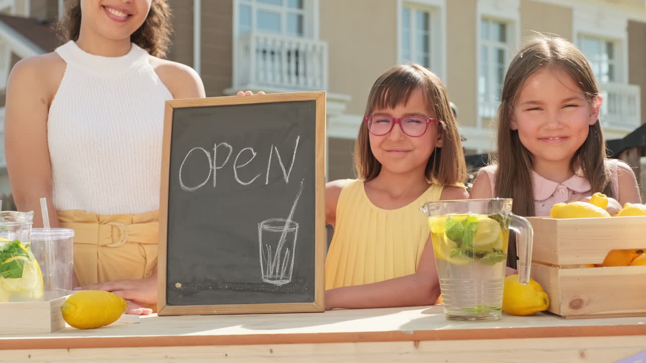 Mom And Daughters Selling Lemonade Outdoors