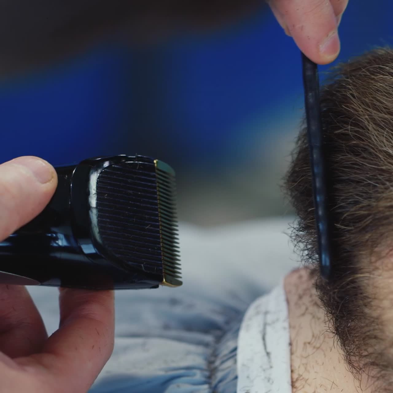 Detaljeret nærbillede af barber, der former en klients skæg