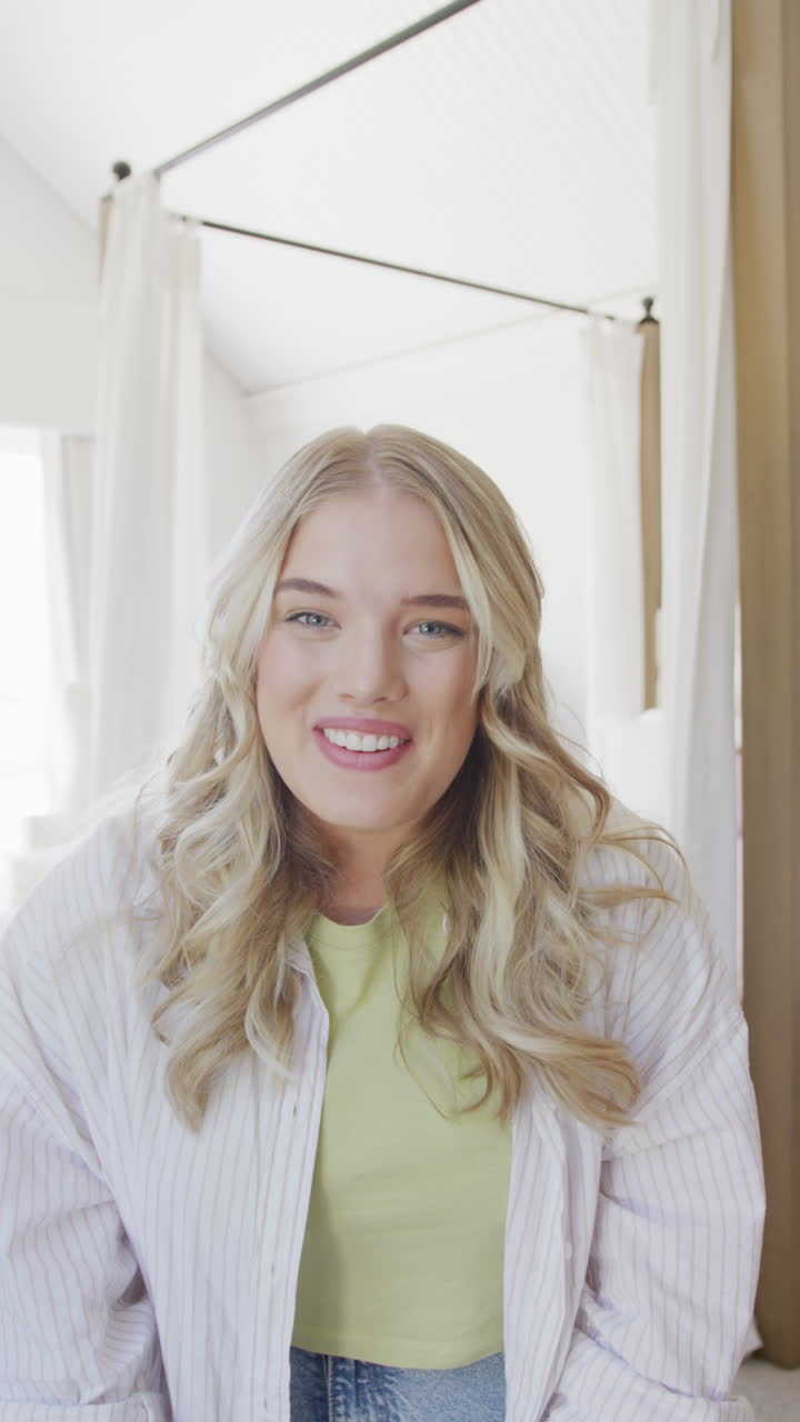 Vertical video of portrait of happy caucasian plus size woman having video call in slow motion