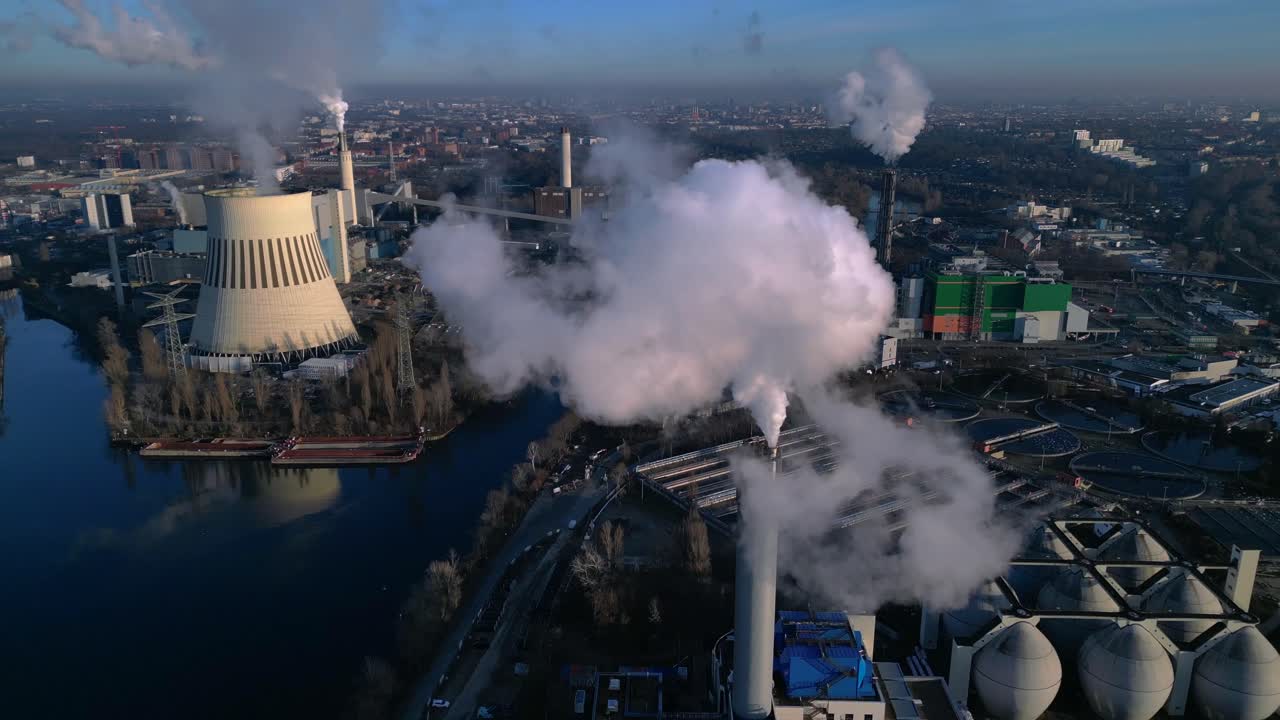 Industrial power Plant chimneys releasing large plumes of smoke pollution into the atmosphere, contributing to environmental damage. Nice aerial view fly through push forward drone
