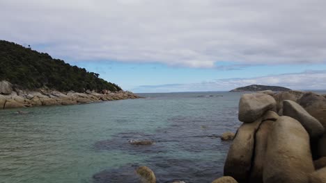 Drone-aerial-moving-forward-over-beautiful-beach-shoreline-with-blue-water-and-nice-rocks-in-Wilsons-Promontory