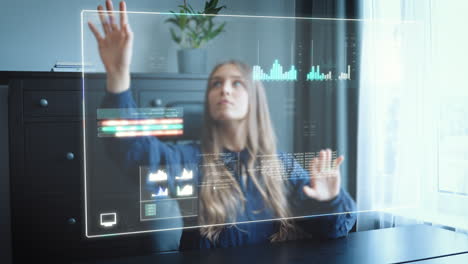 mujer de negocios en la oficina en casa trabaja en una pantalla de holograma futurista y empuja tablas, gráficos y estadísticas a través del control de gestos