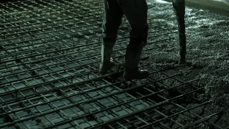 reinforced concrete. worker concretes foundation, rebar, pour cement mortar on reinforcing mesh. builders are building a factory, hangar.