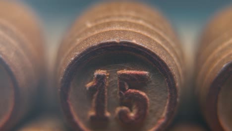 cinematic macro smooth shot of bingo wooden barrels in a row, woody figures, old numbers vintage board game, lucky number 15, slow motion, 4k commercial gimbal movement, dreamy lighting, tilt up