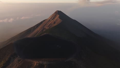 aerial view backwards away from a volcanic caldera on a mountain summit in guatemala