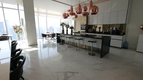área de cocina completamente decorada con barra, área de comedor y taburetes