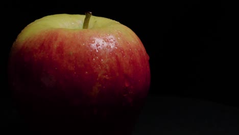 manzana fuji girando fuera del centro sobre fondo negro con espacio de copia, primer plano