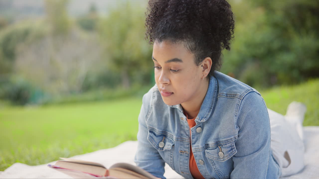 mujer negra, leyendo un libro y relajándose en el parque