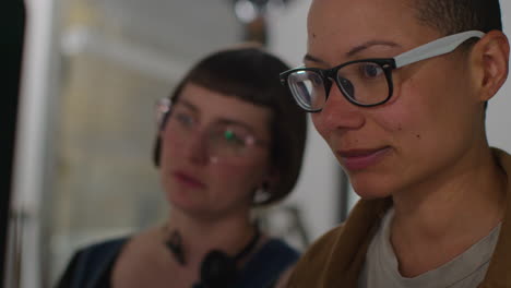 female film director and assistant watching actors shooting movie or video in studio on monitor