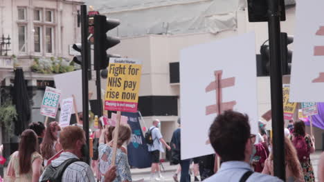 manifestantes marchando por las calles de londres para la protesta del nhs