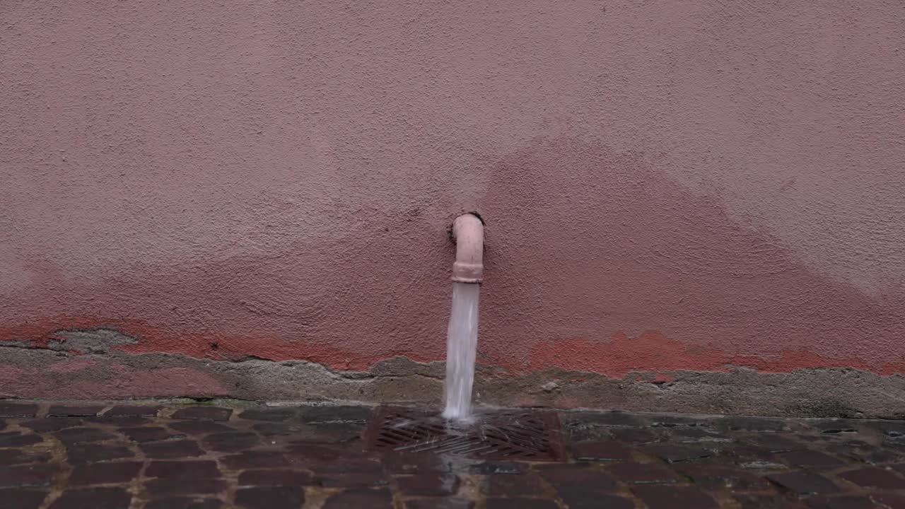 Rainwater From Drain Pipe Flows Through The Drainage On The Walkway. close up