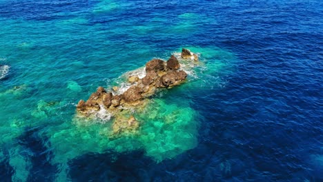 turquoise ocean and rocks at agia eleni beach in greece - aerial static