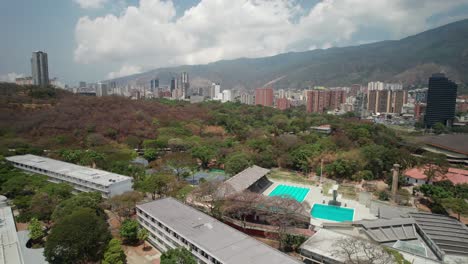 aerial view flying over the central university of venezuela campus with city backdrop