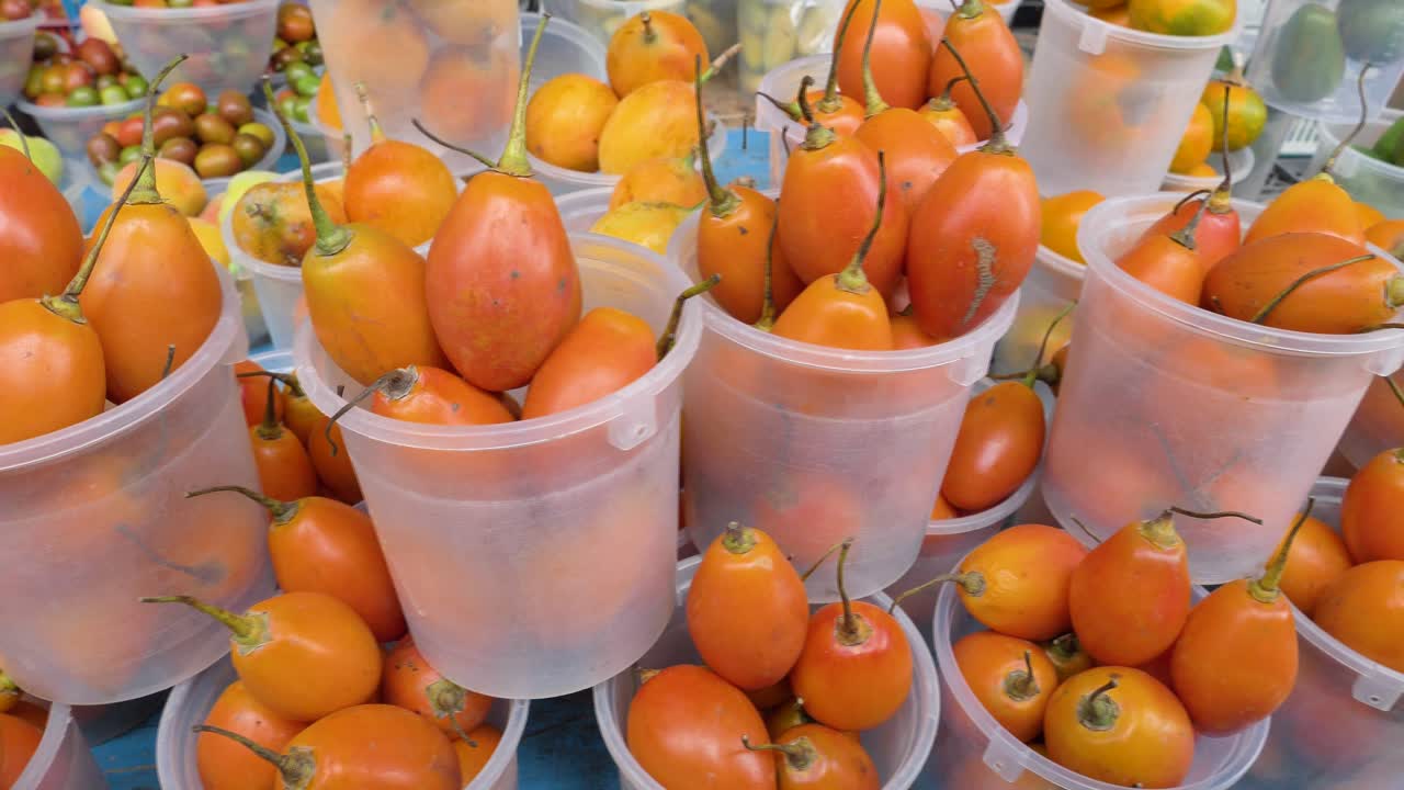 Close view of tamarillos arranged in plastic cups on a market stall in Ecuador