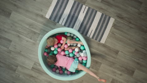 glad couple of kids crawls in dry pool under plastic balls