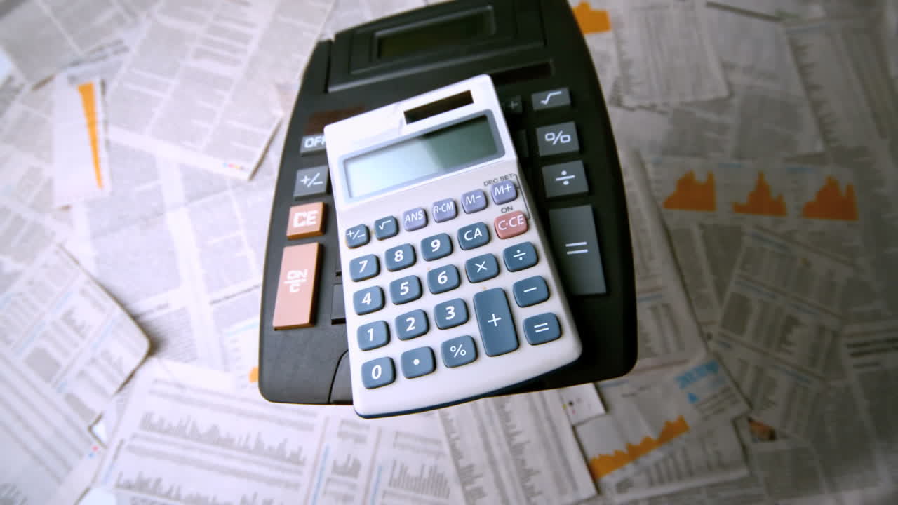 calculadoras que caen sobre hojas de papel
