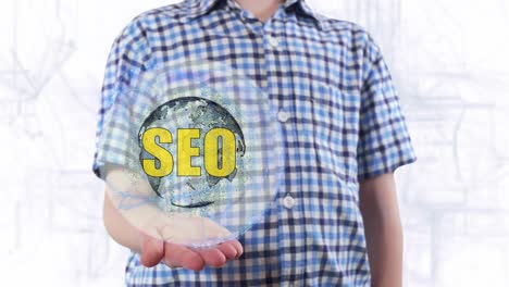 young man shows a hologram of the planet earth and text seo